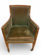 An Edwardian mahogany and satinwood inlaid tub shaped library armchair on square section tapering