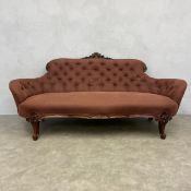 A 19th century carved mahogany sofa in deep buttoned calico raised on cabriole supports. H.88 W.