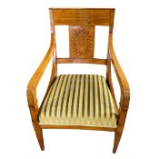 A Biedermeier style satin birch open armchair with wreath decorated splat and shaped arms over the