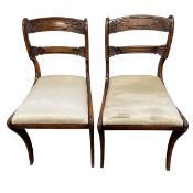 A pair of Regency mahogany bar-back dining chairs with carved backs over the drop-in seats raised on