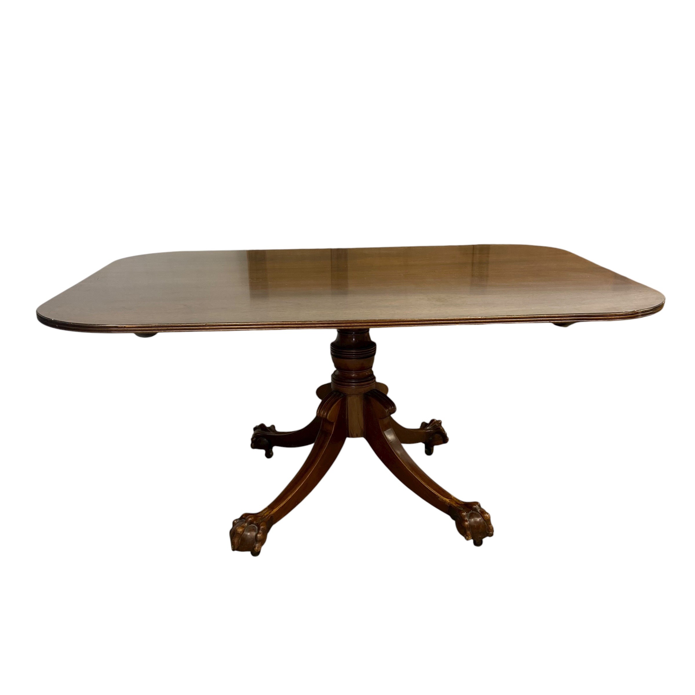 A 19th century mahogany dining table with shaped top over the turned pedestal raised on splayed