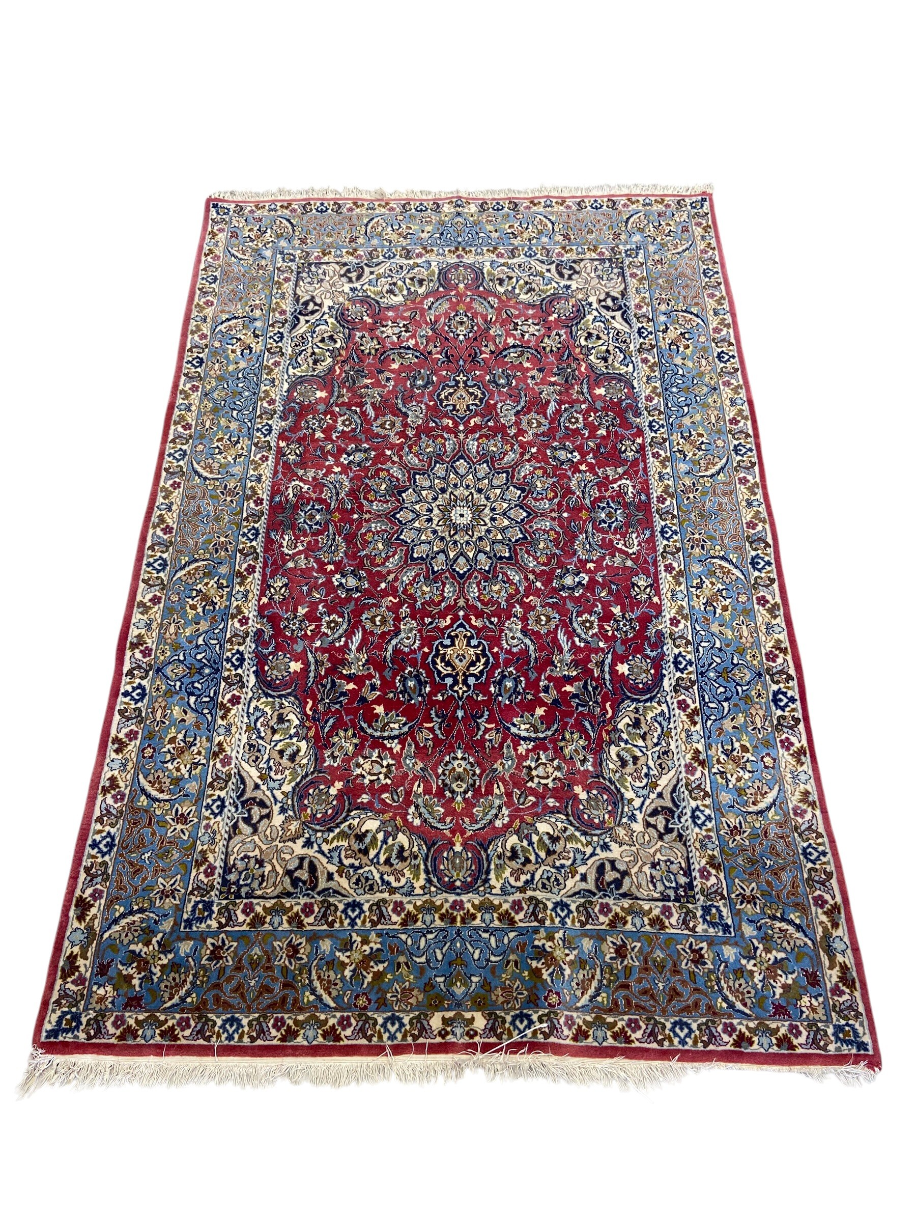 A Persian Najafabad rug with central flowerhead medallion in the polychrome field over a burgundy