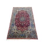 A Persian Najafabad rug with central flowerhead medallion in the polychrome field over a burgundy