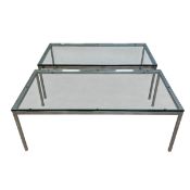 A pair of vintage coffee or side tables with thick rectangular plate glass tops raised on polished