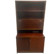 A vintage teak bookcase with two open shelves and fall front compartment over the sliding base