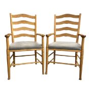 A pair of vintage oak ladderback armchairs. H.107 W.60cm.