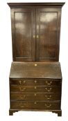 A Georgian oak bureau bookcase with moulded cornice and panel doors enclosing three shelves over the