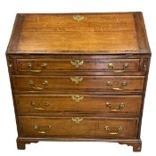 A Georgian oak bureau with fall front enclosing fitted interior over four long graduating drawers