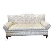 A vintage two seater sofa with shaped back and scrolled arms over the re-upholstered printed