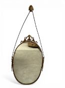 A vintage 19th century style wall mirror with oval scrolled cresting over the oval plate in a beaded