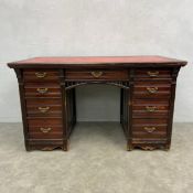 A 20th century twin pedestal desk with red gilt and tooled leather top over an arangement of