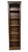 A 20th century oak open bookcase with six shelves flanked by carved pilasters raised on a square