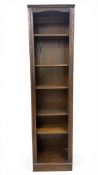 A 20th century oak open bookcase with six shelves flanked by carved pilasters raised on a square