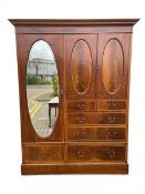 A C.1900 mahogany compactum wardrobe with dentil moulded cornice over an arrangement of mirrored and