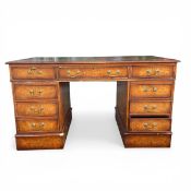 A 19th century burr elm twin pedestal desk with gilt and tooled green leather top over an