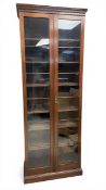 An early 20th century mahogany bookcase or display cabinet with dentil moulded cornice over the