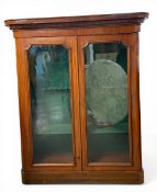 A 19th century mahogany gun cabinet with moulded cornice over two glazed doors enclosing a fitted