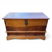 A 20th century teak mule chest with hinged top over two base drawers raised on a shaped plinth base.