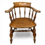 A C.1900 elm smoker's bow armchair with shaped back and arms over the saddle seat raised on turned