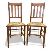 A pair of C.1900 Arts & Crafts oak side chairs with slatted openwork backs over the printed