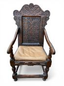 A 17th century oak Wainscot armchair with carved and shaped back and arms over the matched, fitted