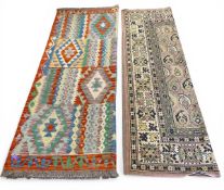 A vintage Afghan flat-weave Kilim carpet with allover geometric polychrome design together with a