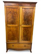 A 19th century walnut wardrobe with dentil moulded cornice and figured panel doors enclosing a