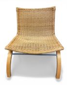 A vintage early noughties Björket lounge chair with shaped rattan back and seat raised on arched