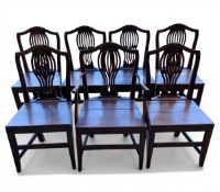 A set of seven Georgian oak dining chairs each with shaped back and openwork splat over the plank