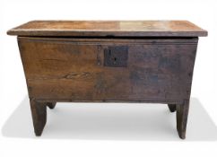 A 17th century six-plank oak coffer with its original iron hinges and lock-plate raised on shaped