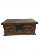 An early 18th century oak bible box with iron hinges and latch, and a carved flowerhead frieze.