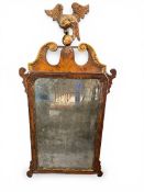 An early Georgian burr walnut fret cut wall mirror with carved giltwood ho-ho bird cresting and