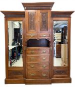A late 19th century walnut breakfront compactum wardrobe having a moulded cornice and fluted