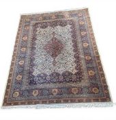 A contemporary Tabriz style carpet with central pole medallion in a scrolling field over a beige