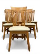 A set of six contemporary oak dining chairs with shaped, slatted backs over cream faux leather