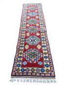 A contemporary Kazak style runner with six stepped diamond lozenge medallions over a burgundy ground