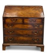A Georgian mahogany bureau with crossbanded fall-front enclosing a fitted interior over two short