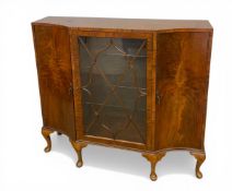 An mid 20th century flame mahogany display cabinet with central astragal glazed door enclosing glass