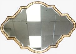 A large contemporary wall mirror of quatrefoil form with a shaped bevelled plate in a gilt