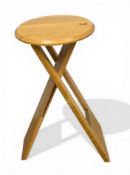 A vintage beech Suzy Stool with circular seat raised on folding A-frame supports by Adrian Reed &