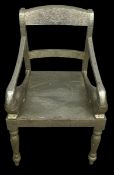 A vintage Anglo-Indian embossed metal clad armchair with shaped back and figural arms raised on