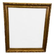 A large 19th century carved giltwood picture frame with a beaded border in a laurel leaf and berry