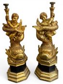 A pair of large and impressive carved giltwood floor standing figure group candelabras; cherubs