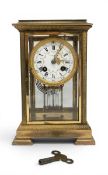 A 19th century mantle clock, the gilt brass four glass case housing a suspended French cylinder