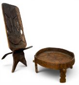 A vintage hand carved African hardwood birthing or chiefs chair in two parts together with a vintage