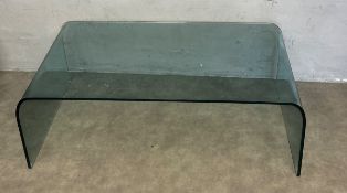 A contemporary bent plate glass coffee table. H.38 W.111 D.60cm