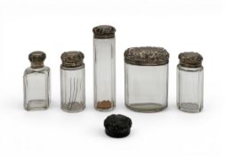 A collection of Victorian cut glass dressing table jars with embossed silver lids. Gross weighable