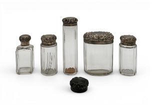 A collection of Victorian cut glass dressing table jars with embossed silver lids. Gross weighable