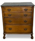 A 19th century oak chest with black marble top over four long graduating drawers raised on carved