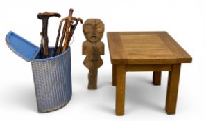A collection of walking sticks in a loom style corner linen box, a carved figure and a teak lamp